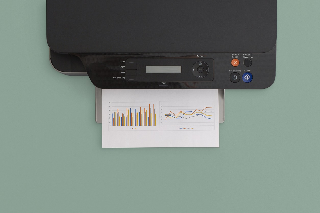 A printer on a green background printing multiple graphs