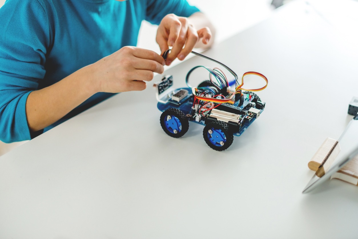 A student working on a small robotic car. 