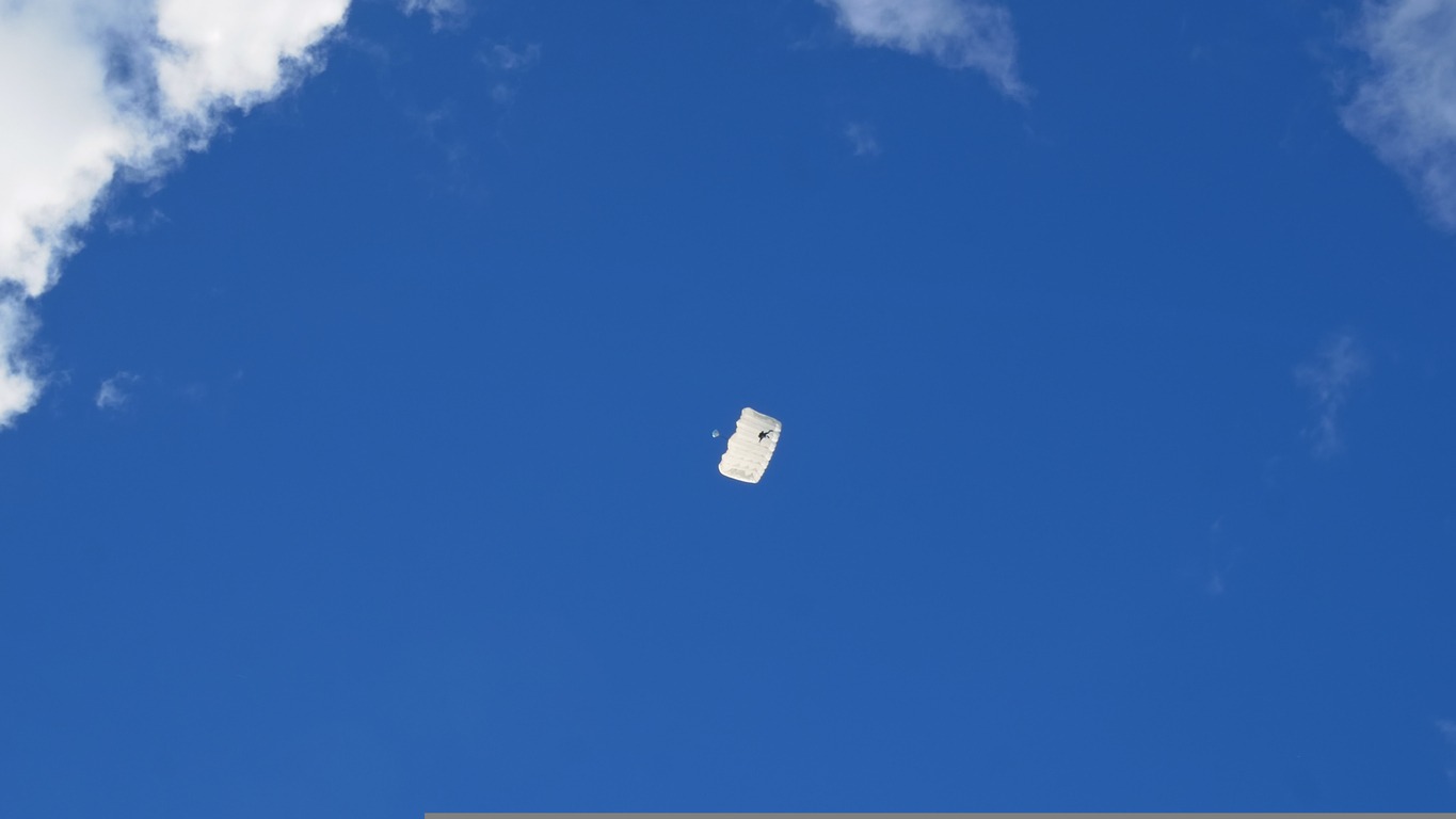 A white parachute falling from the sky