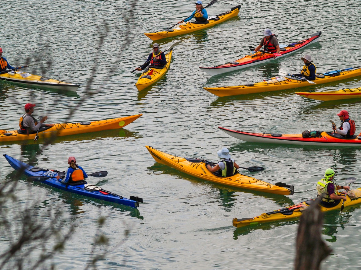 Group of several kayakers gathers together before heading off on an on-water experience.