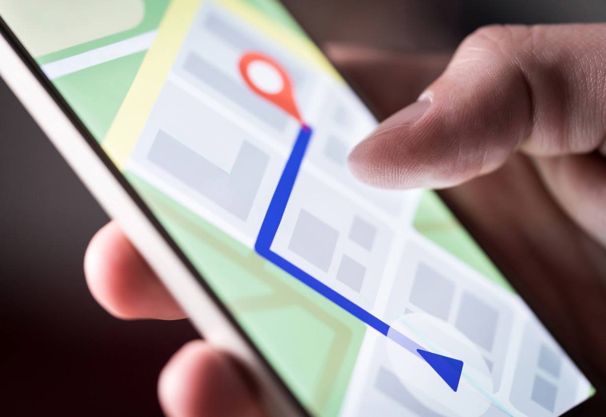 Map application in smartphone. Man navigating in the city with a mobile phone. A person using a cellphone and searching for a hotel with a navigation app. Macro close-up of the screen