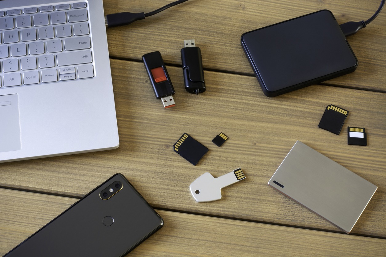 Multiple SD cards alongside other devices on a table.