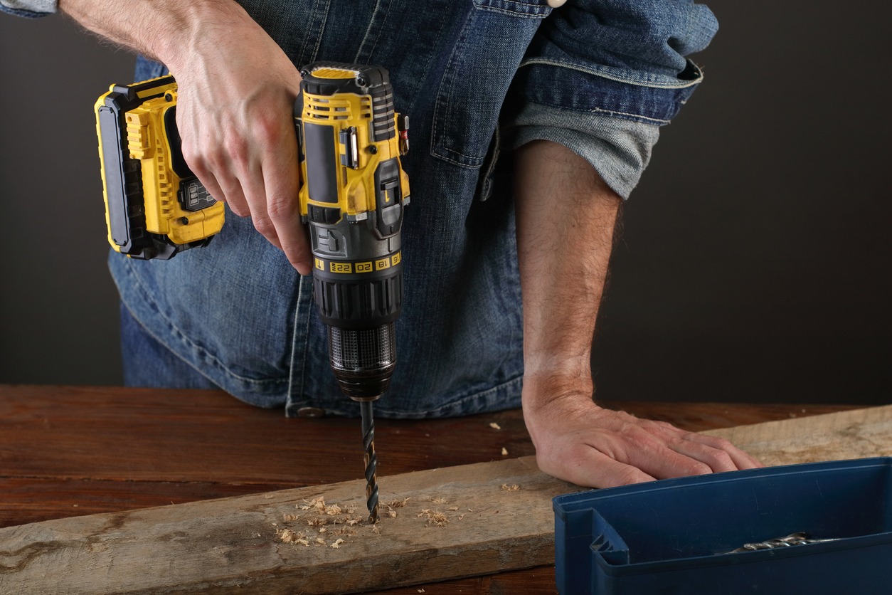 Person using power drill to make a hole