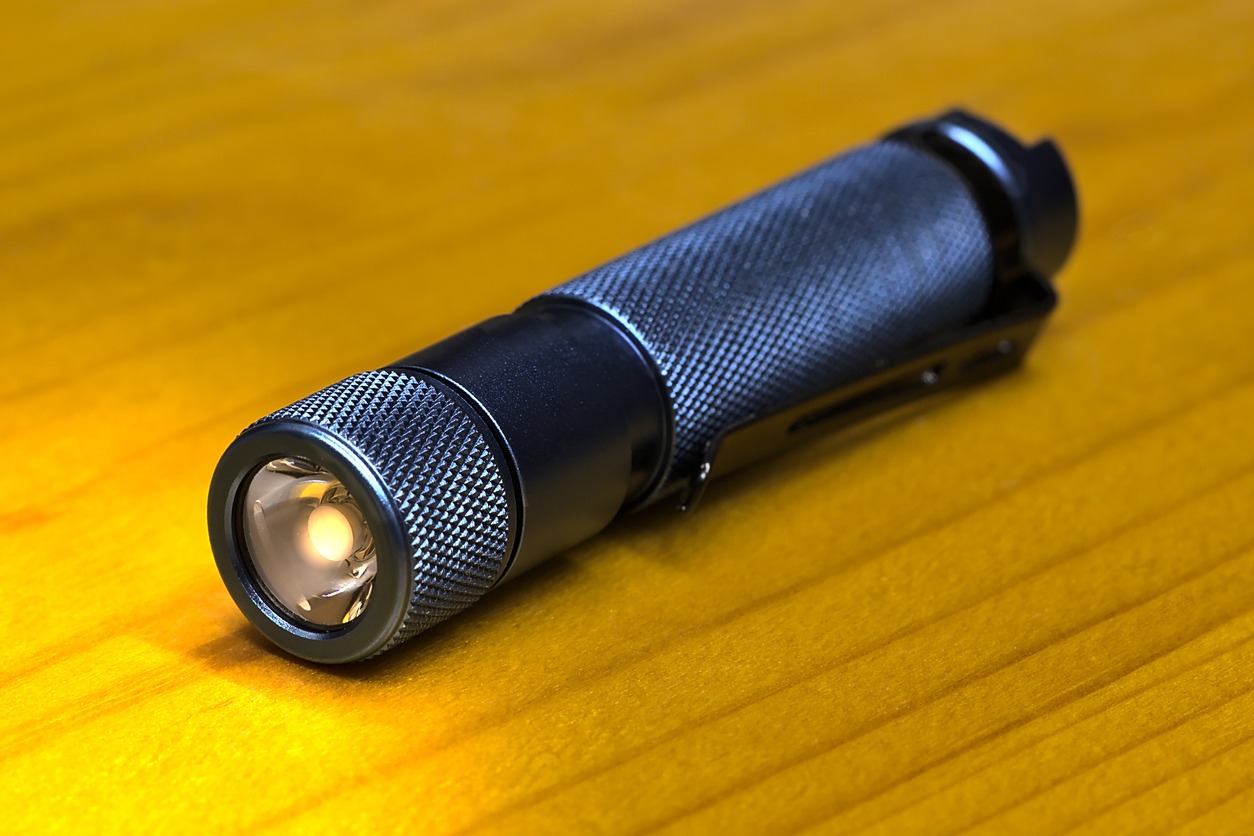 Tactical flashlight on the wooden table