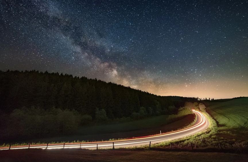 a-long-exposure-photo-of-a-long-road-at-night