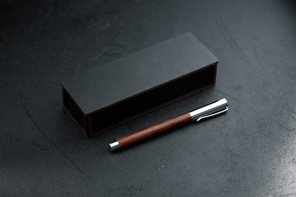 A set of expensive military pens in wooden boxes, compositions on a dark background with attributes. Luxury gift pen