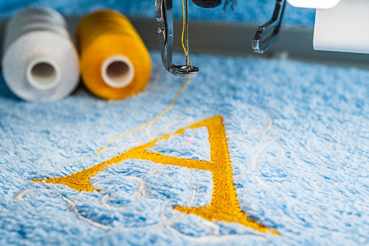 An alphabet design on towel in hoop of embroidery machine
