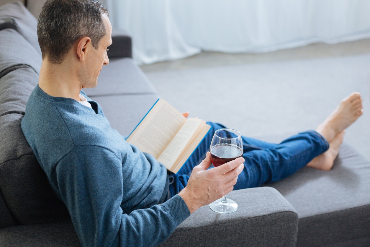 calm man reading book with wine