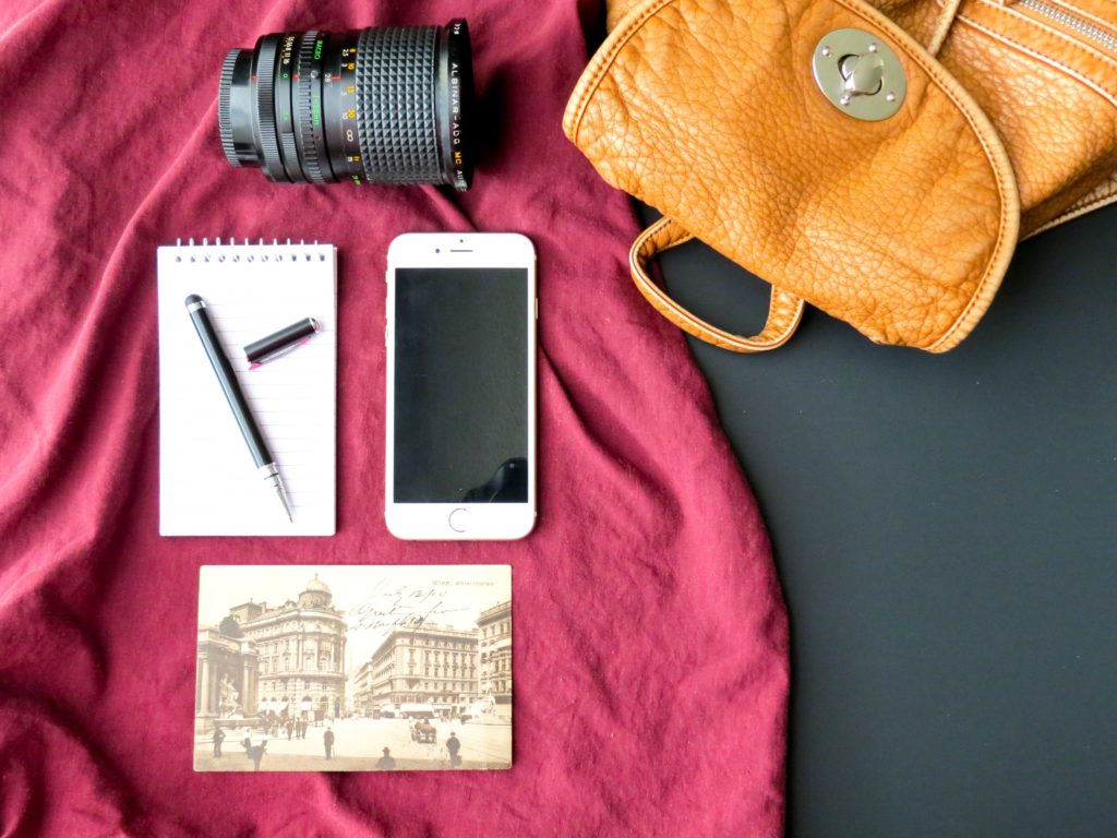 flat lay photography of iphone notebook and dslr