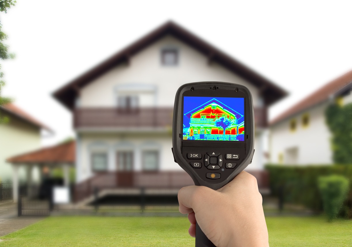 person using a thermal camera to inspect a house