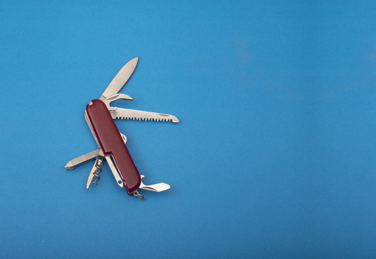 Red color Swiss Army knife on blue banner template