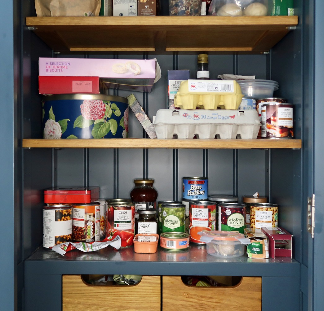 Studio set up of a food store cupboard, larder or pantry. Basic staple provisions