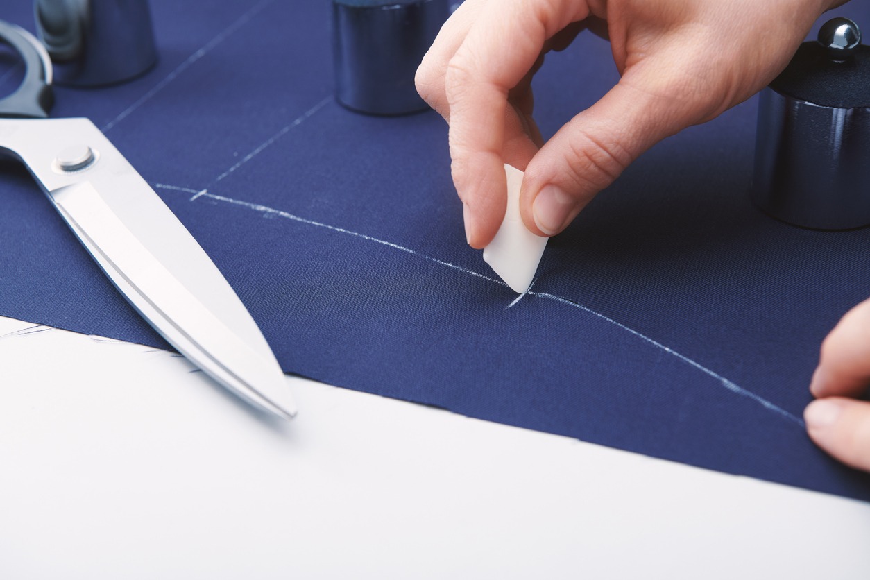 Tailor makes markings with chalk on the fabric