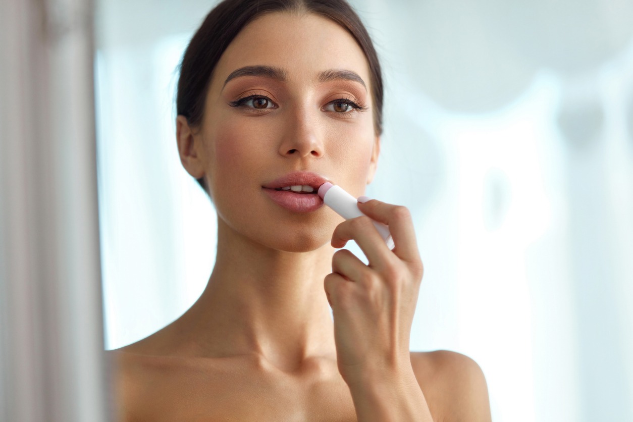 Beautiful Woman With Beauty Face Applies Balm On Lips. Skin Care