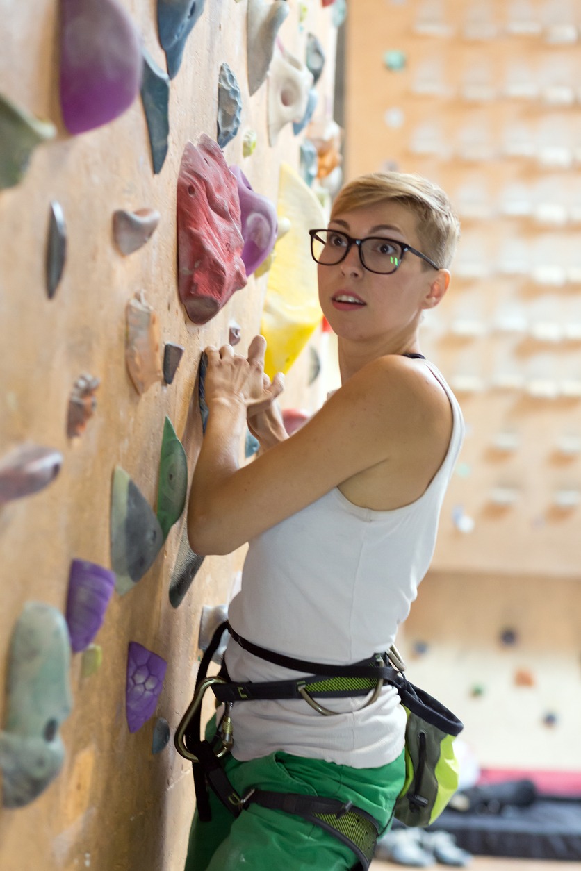 A female rock climber wearing glasses