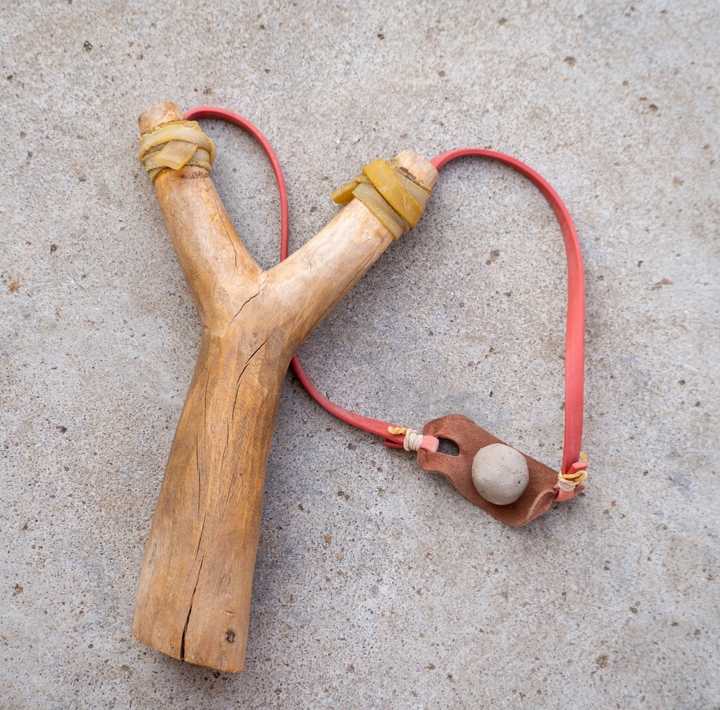 A wood slingshot on the ground.