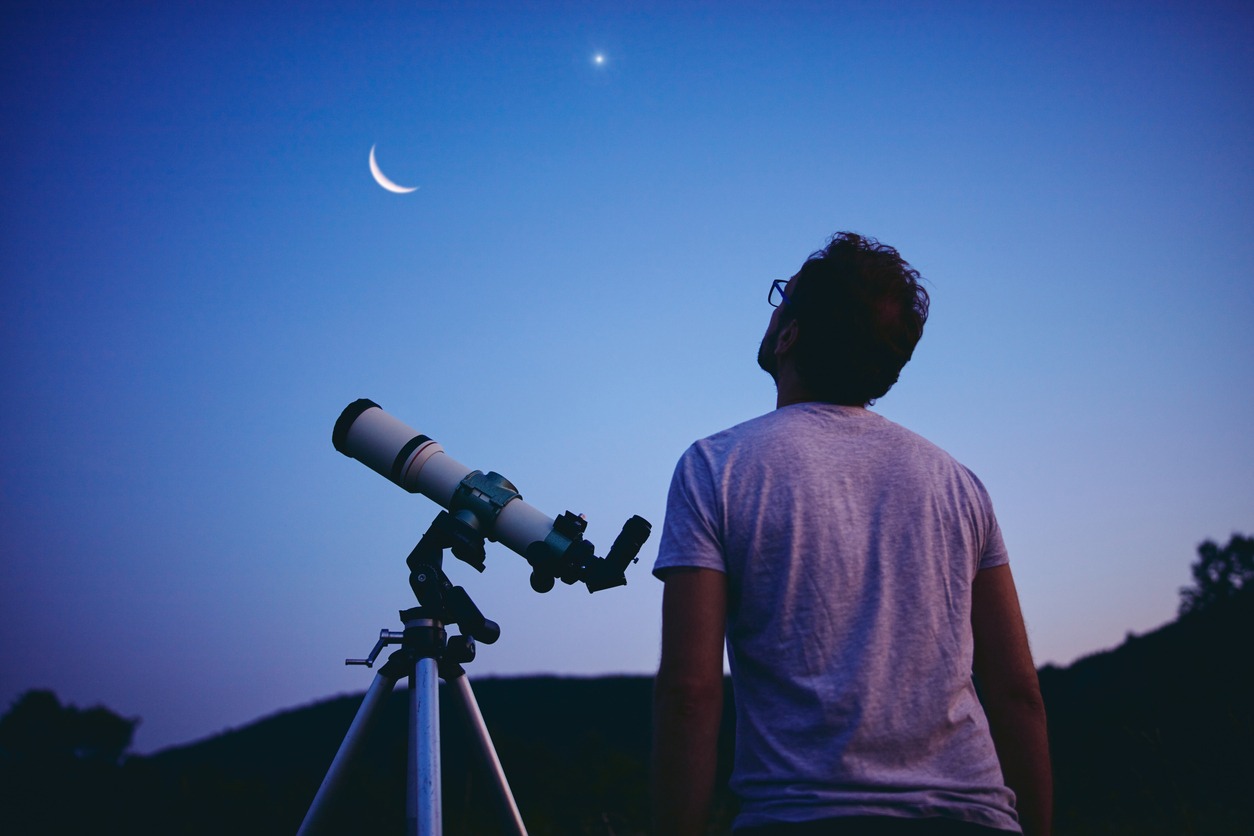 Astronomer with telescope watching stars