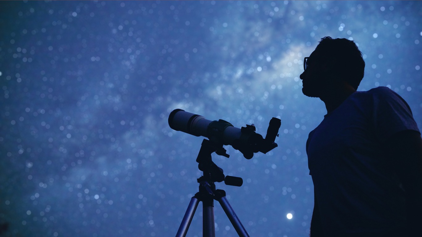 Astronomer with telescope watching stars