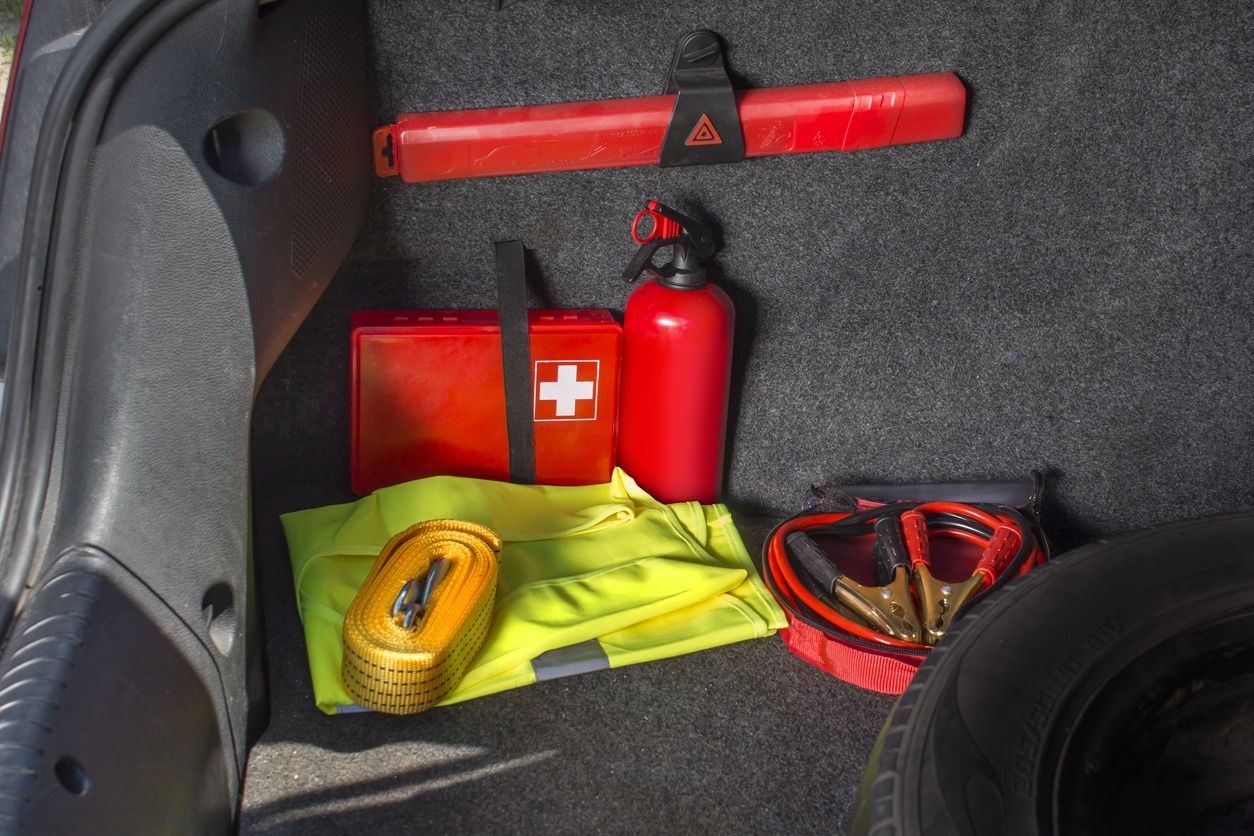 First aid kit, fire extinguisher, and fire extinguisher inside a car.
