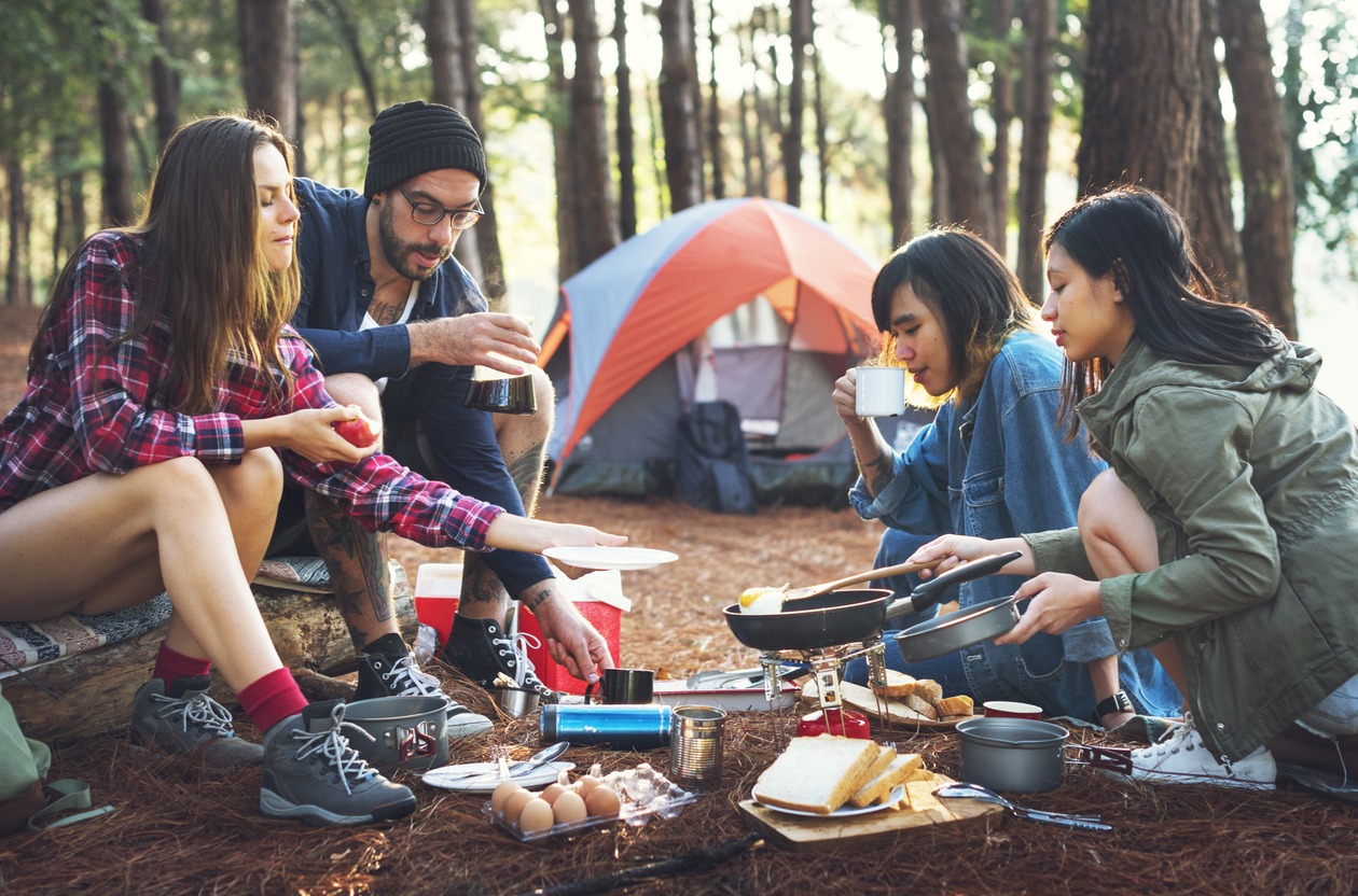 Friends eating while camping in the forest