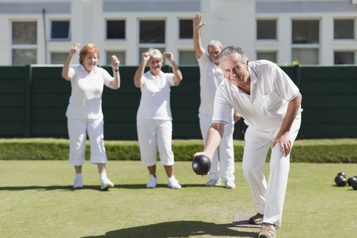 Older people playing lawn bowling