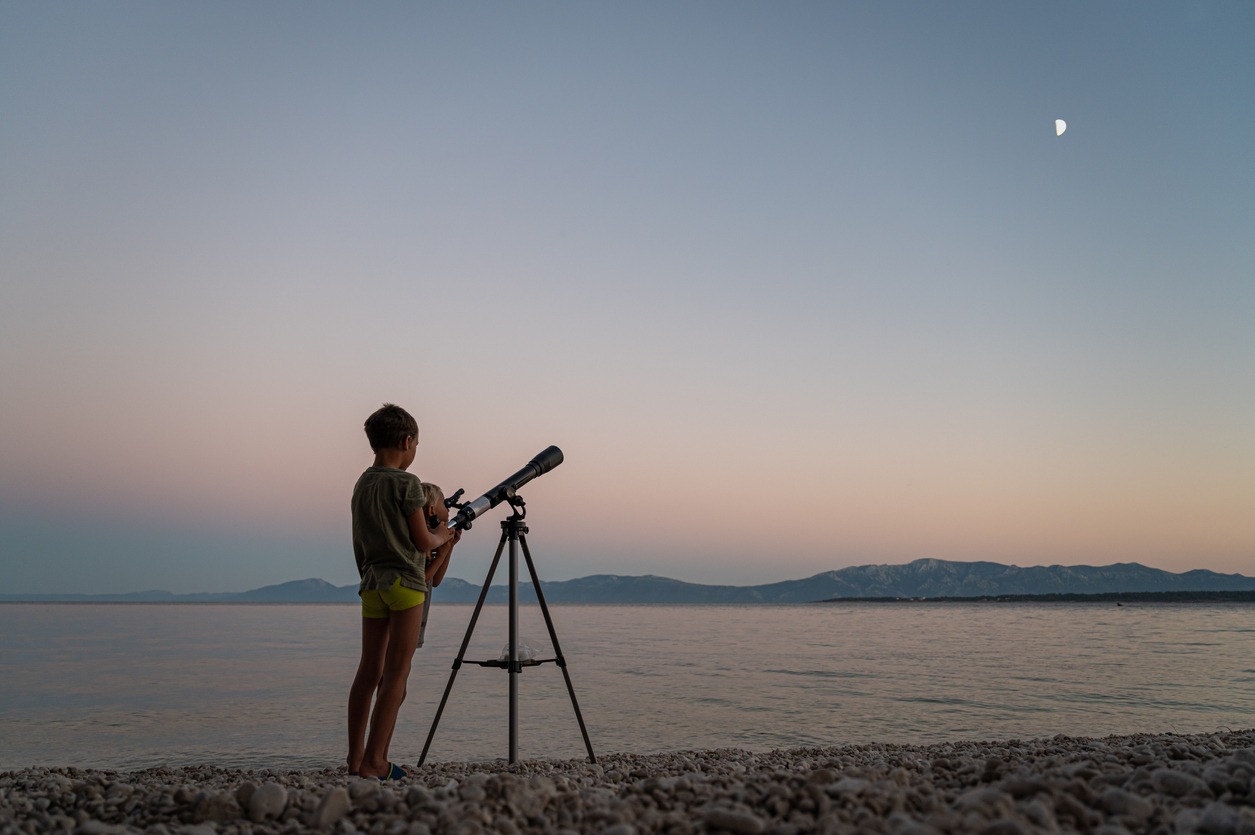 Person on beach with telescope