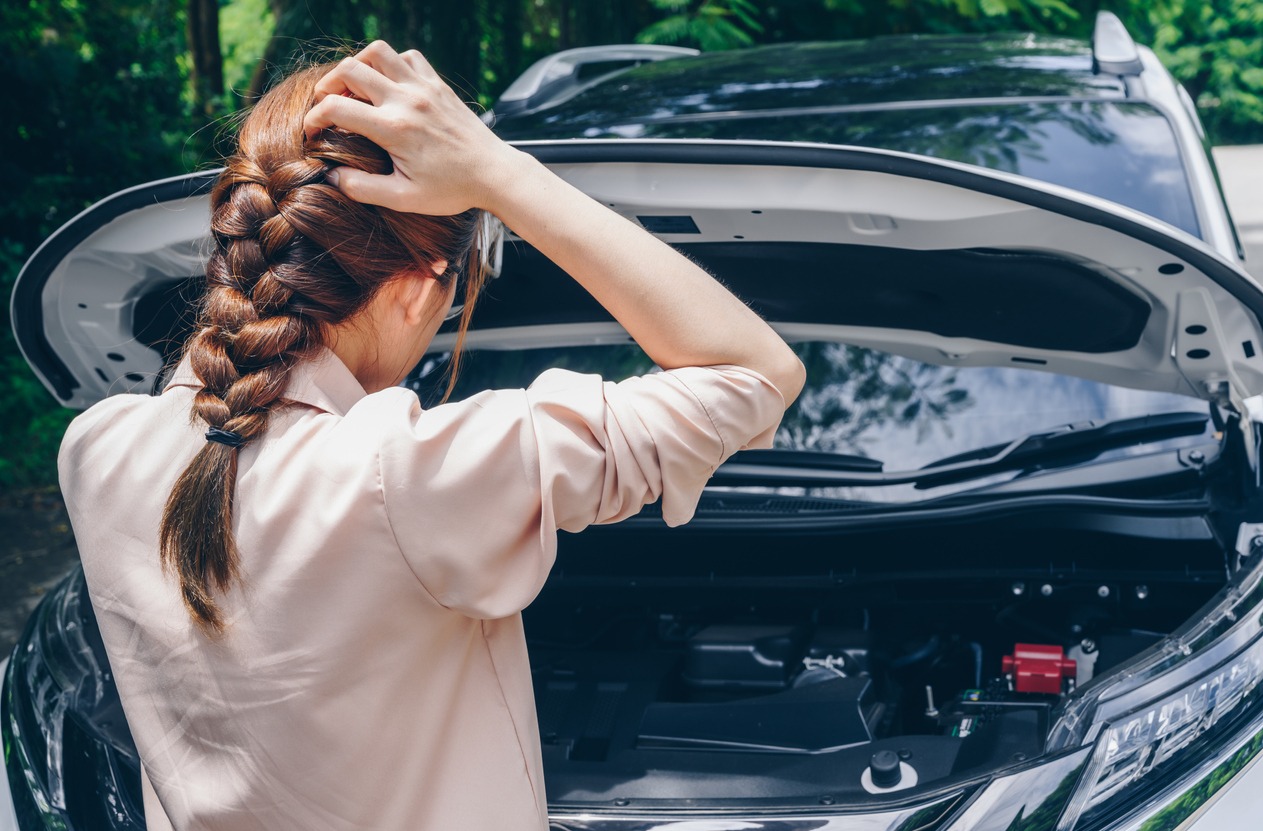 Woman standing in front of the car worried