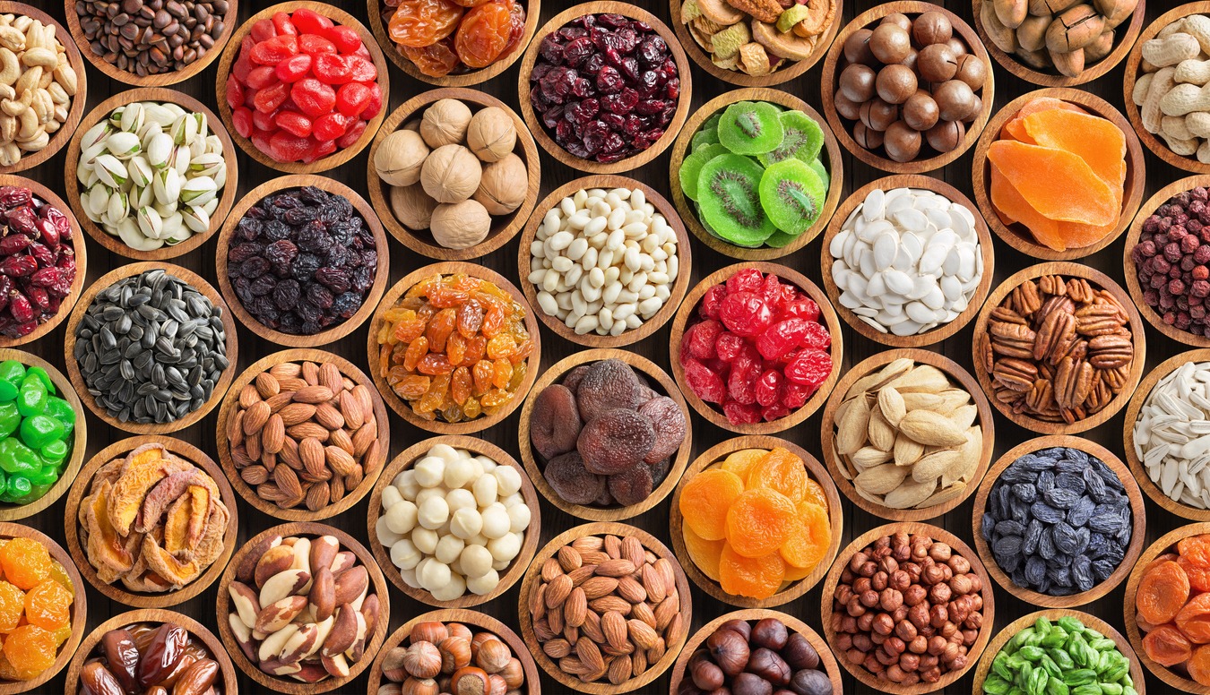 assorted nuts and dried fruit background. organic food in wooden bowls, top view