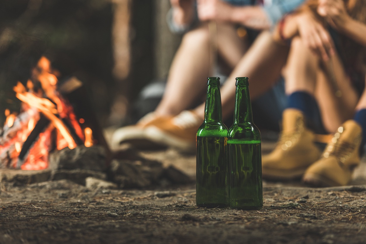 bottles of beer next to bonfire