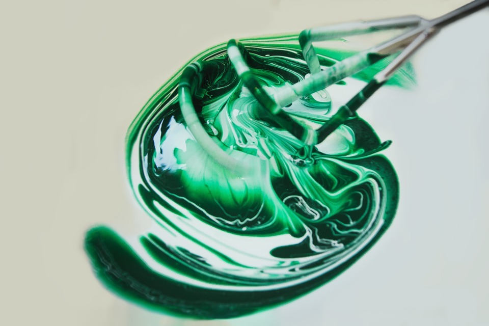 mixing white and green paint with mixer drill bit