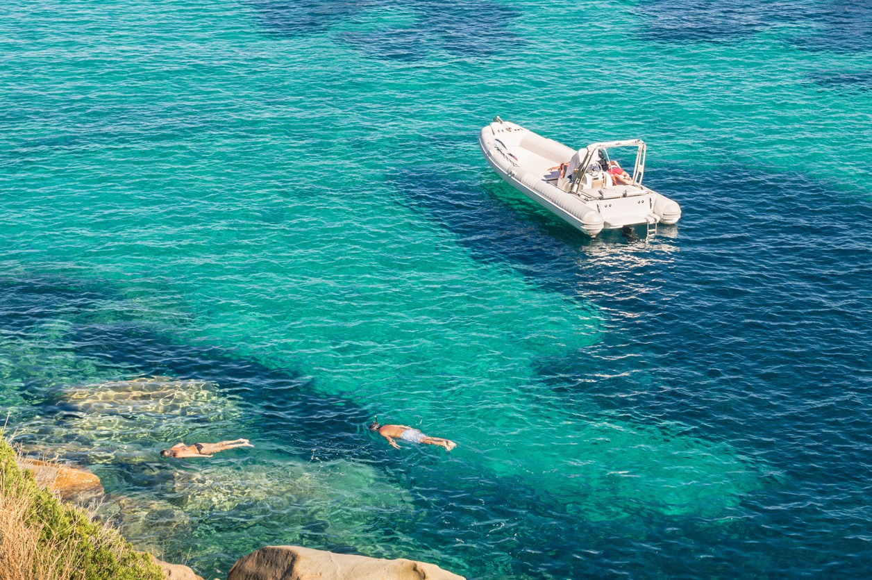 Modern luxury dinghy on turquoise sea with clear blue water in tropical island - People snorkeling in exclusive exotic travel destination - Vacation concept with friends having fun together