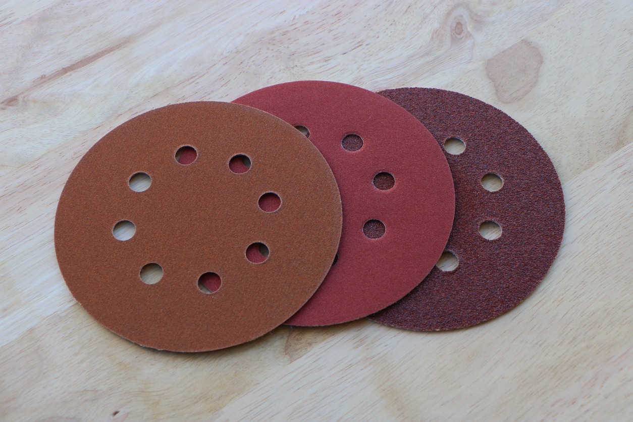 Circular sanding pads on wooden background