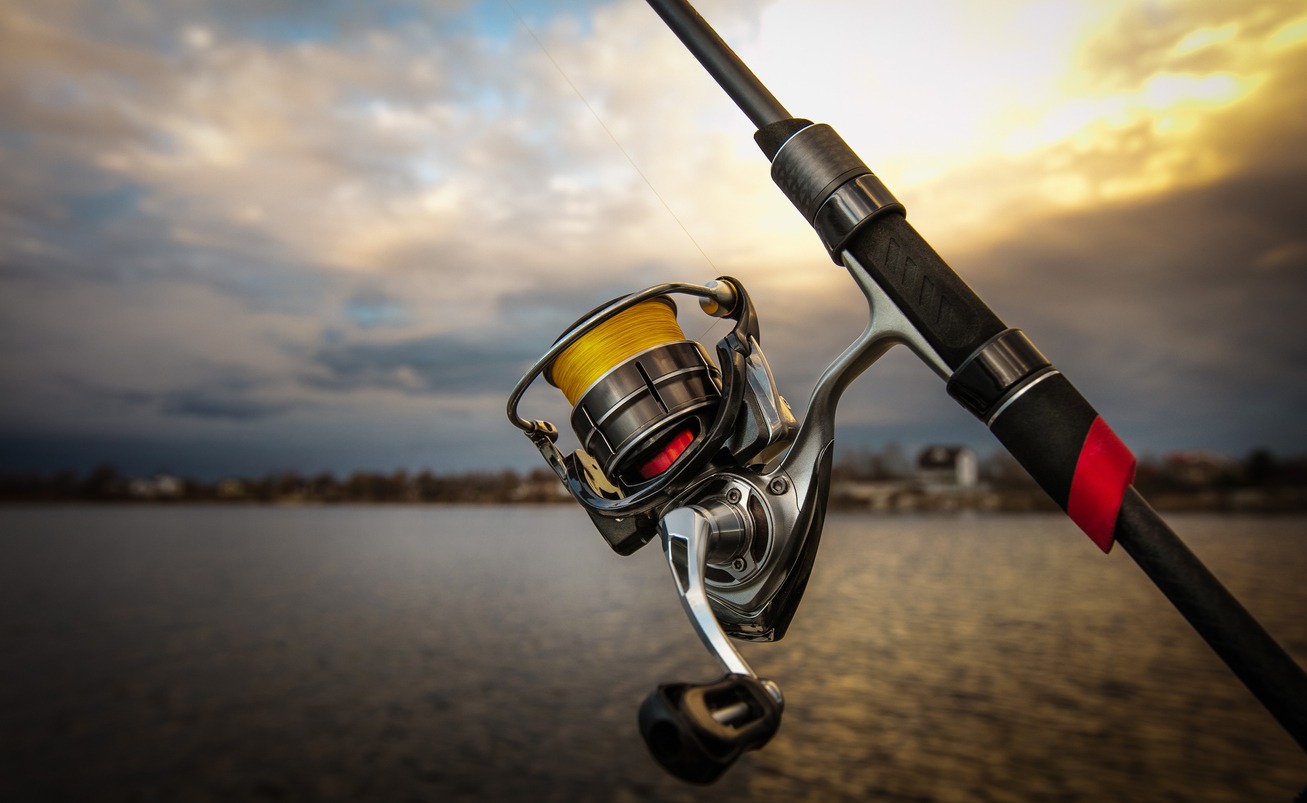 Fishing reel and rod, blurred background.