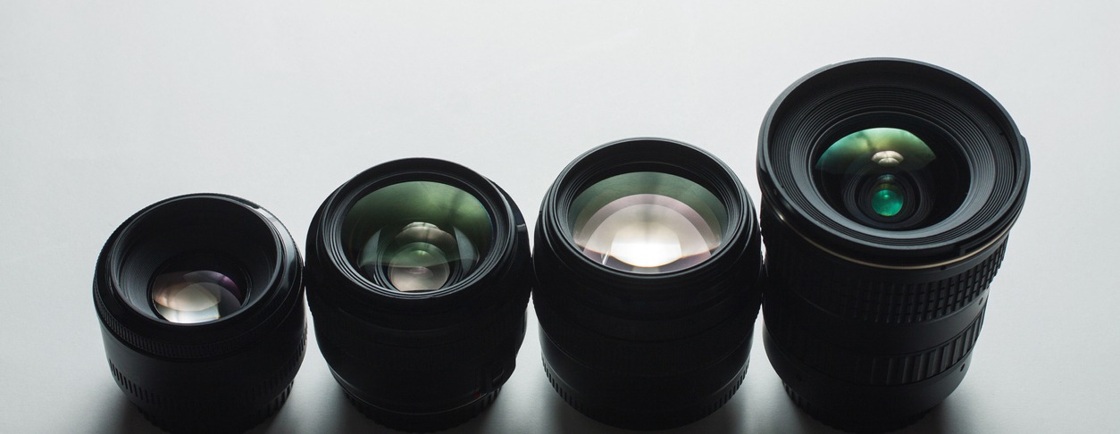 Different types of DSLR lenses on a white surface
