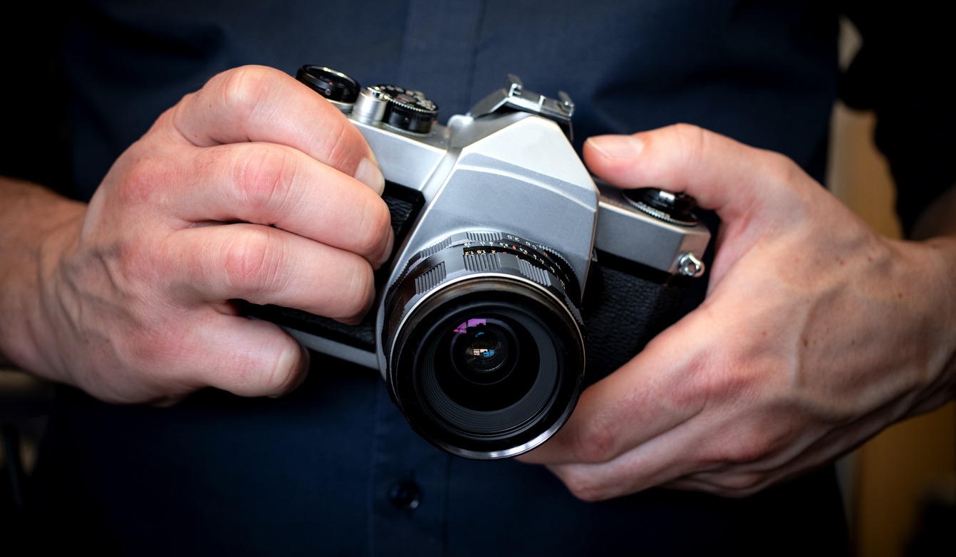 Man holding an old Pentax film camera