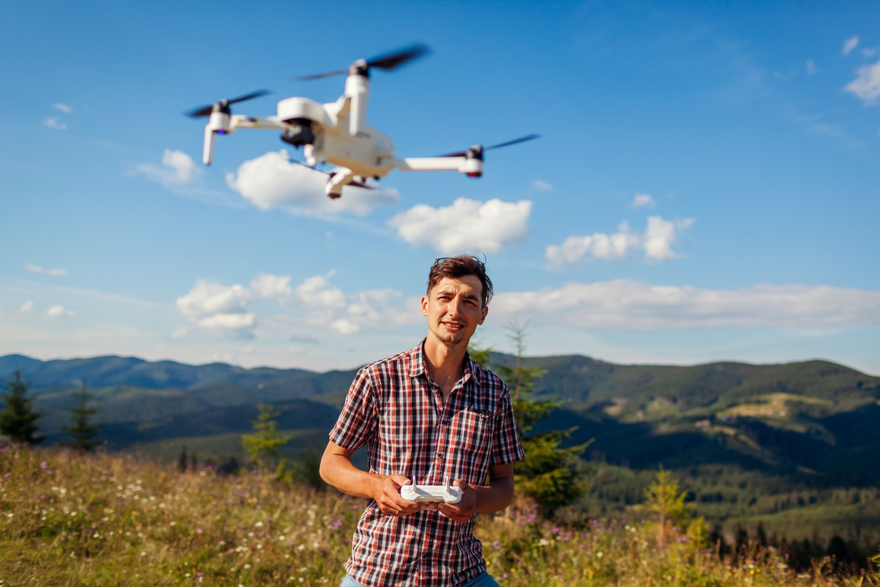 Man operating a drone in an open field