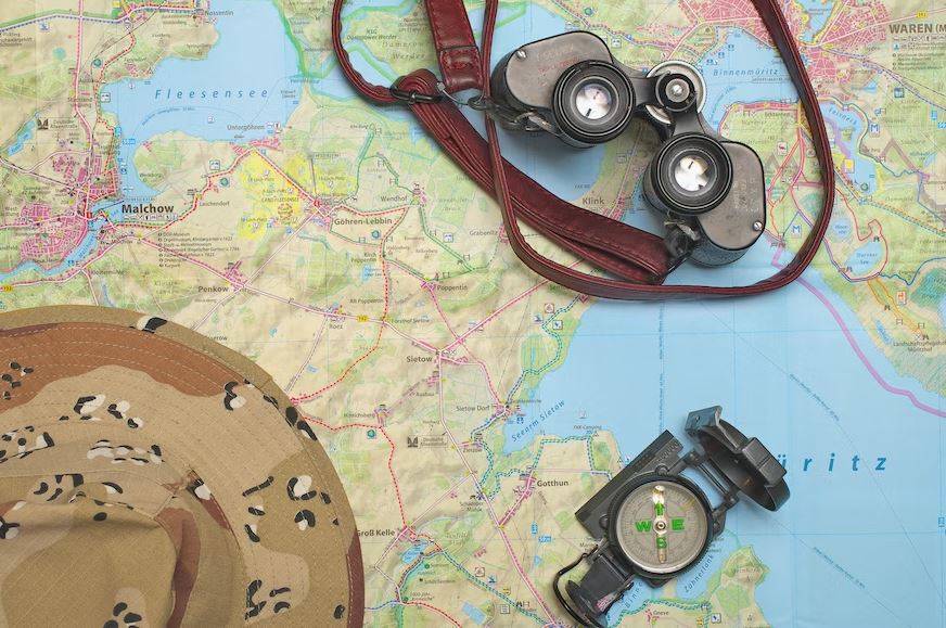 binoculars and a compass on top of a map