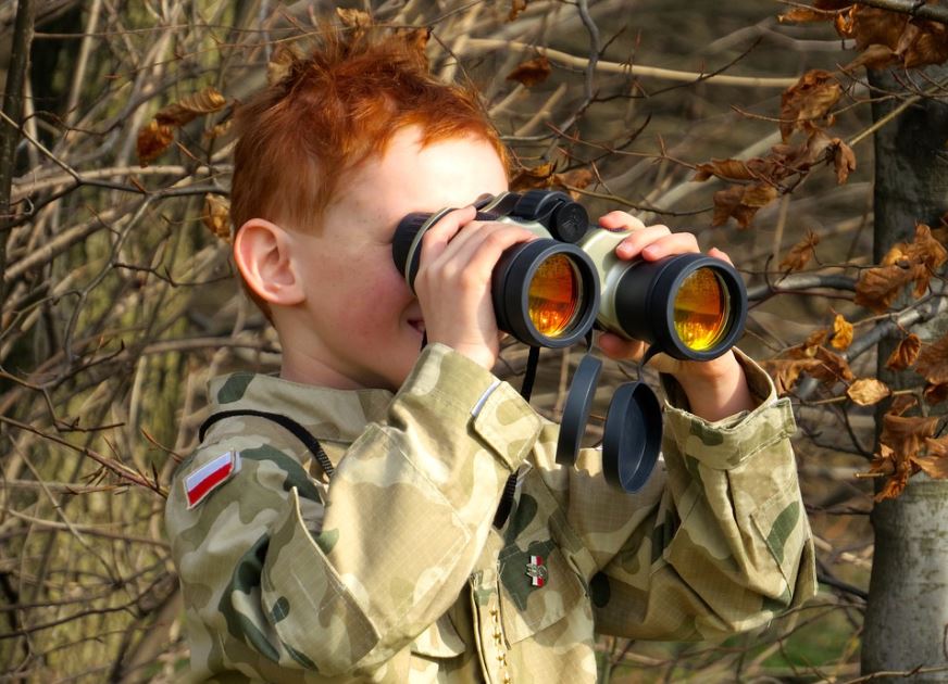 child using binoculars outdoors