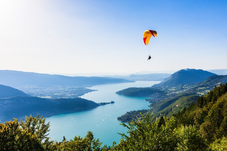 A person paragliding atop a beautiful lake
