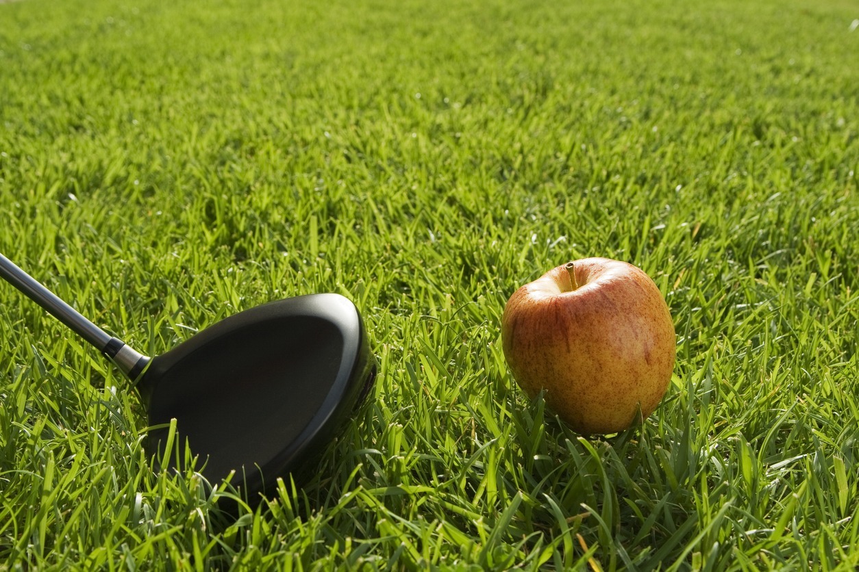 An-apple-and-golf-club-on-the-grass