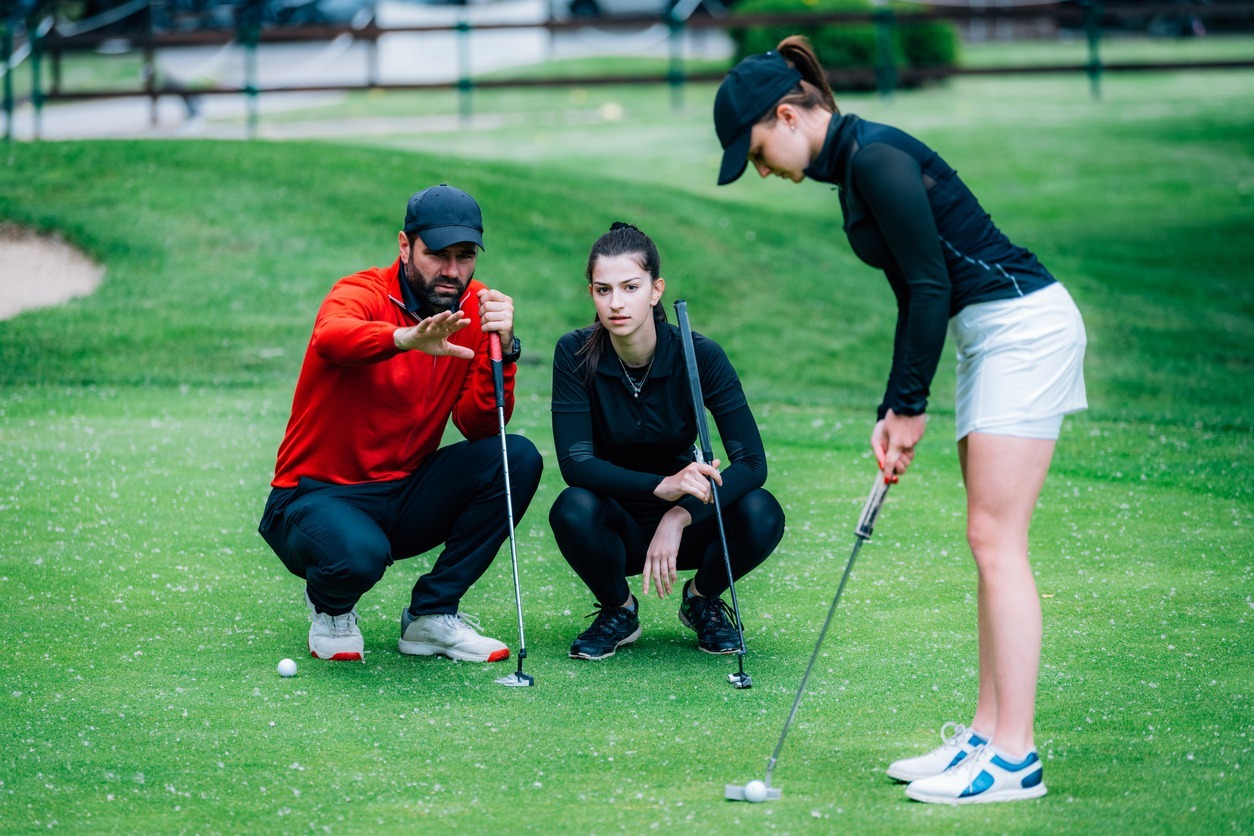 Golf-instructor-teaching-two-golf-newbies