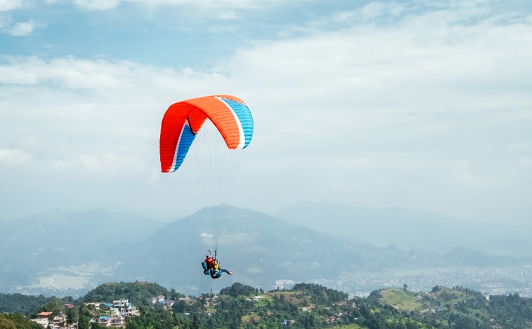 Paragliding with instructor using colorful paraglider over Pokhara, Nepal