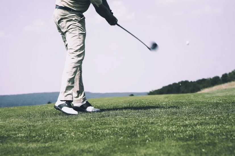 green-grass-man-swinging-a-golf-club-golf-ball-flying-across-the-course