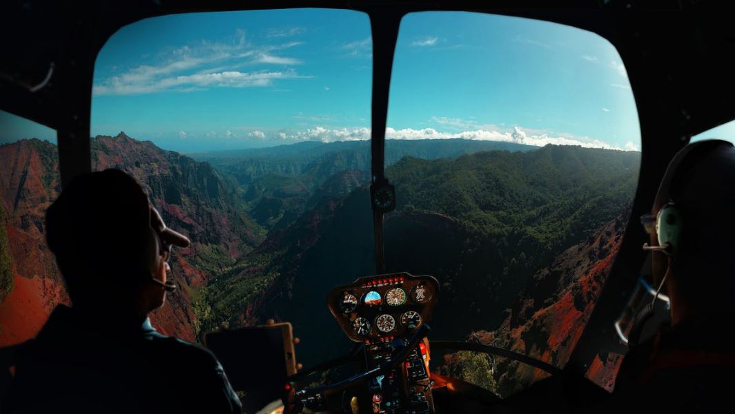 two pilots in an aircraft flying over mountains