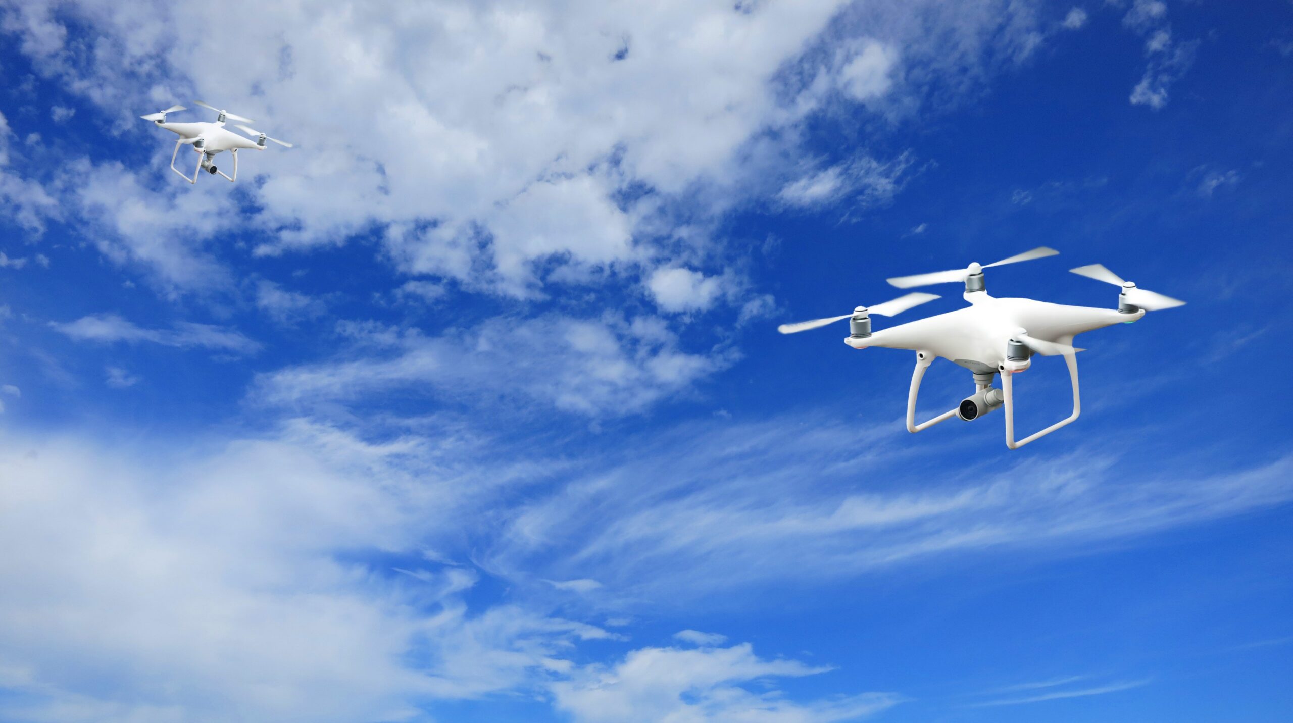 2-Quadcopter-Under-Blue-Sky-and-White-Clouds-scaled