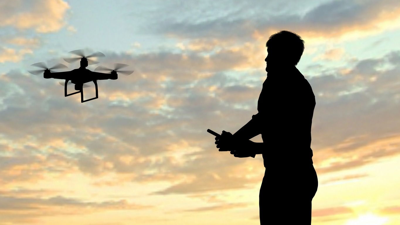 Man operating a flying drone