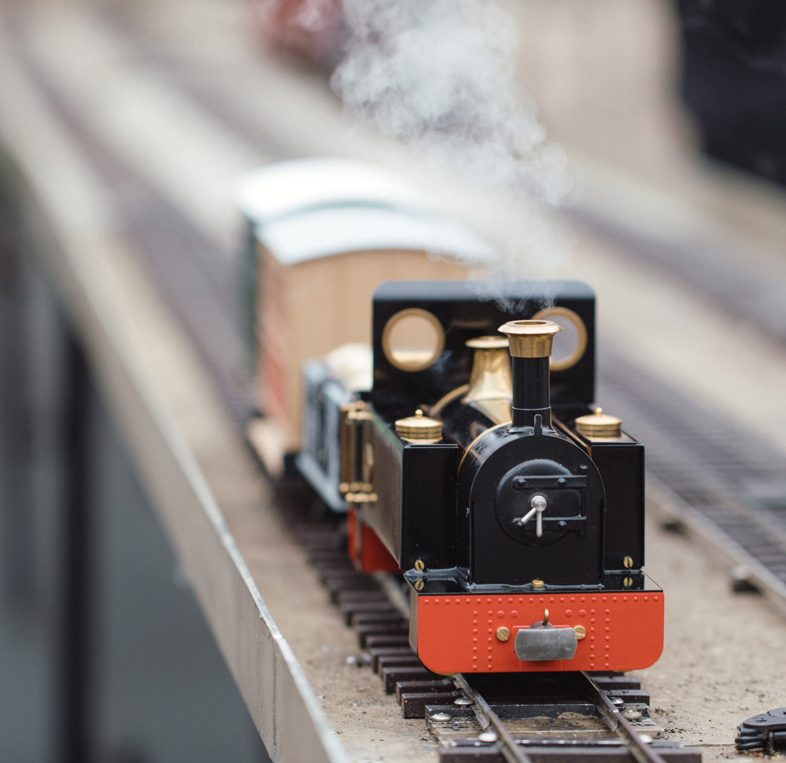 Small model steam engine moving on train tracks