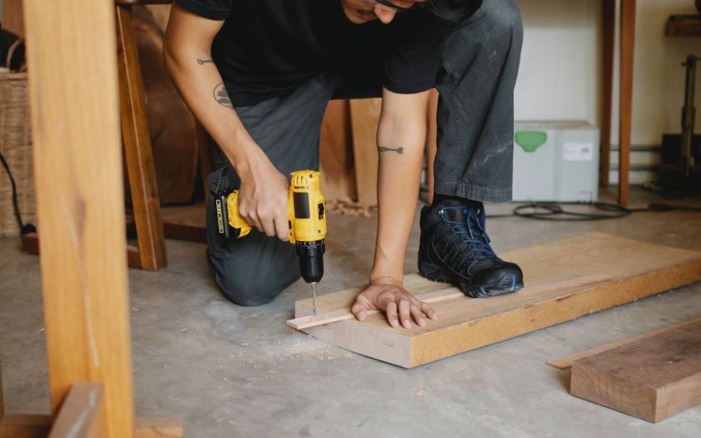 man-using-a-cordless-drill-on-wood
