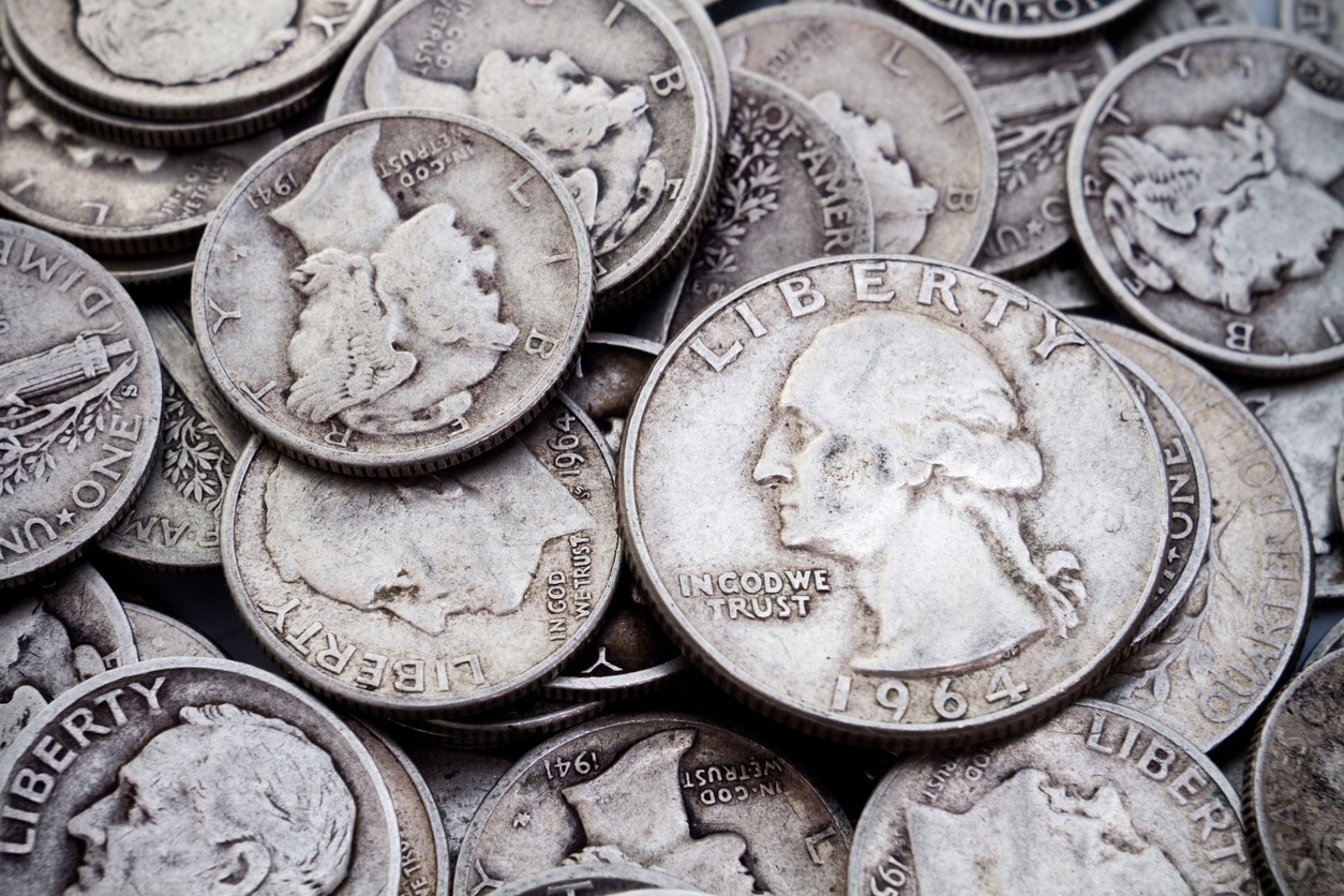 A pile of old circulated, worn collectible silver dimes and quarters