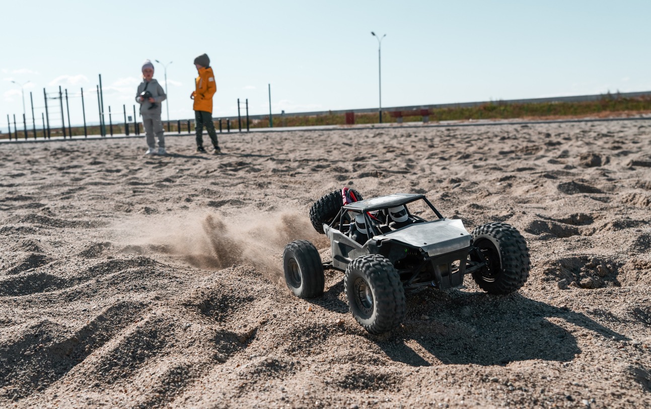 Car, Child, Electronics Industry, Toy, Robot, Carriage, Off-Road Vehicle, Remote Control, Electronics Store, Sand, Wheel, Wireless Technology, Auto Racing, Baby – Human Age